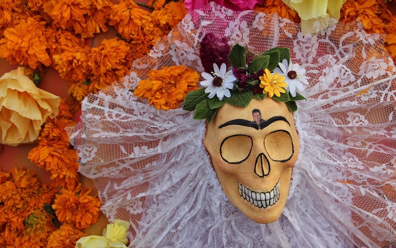 Calavera decorada con flores y encaje en ofrenda universitaria de la Megaofrenda UNAM 2025.