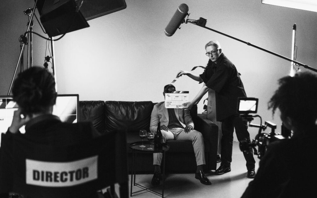 Equipo de filmación en un set de cine, con un director, camarógrafos y un actor durante una toma de la nueva ola del cine mexicano.