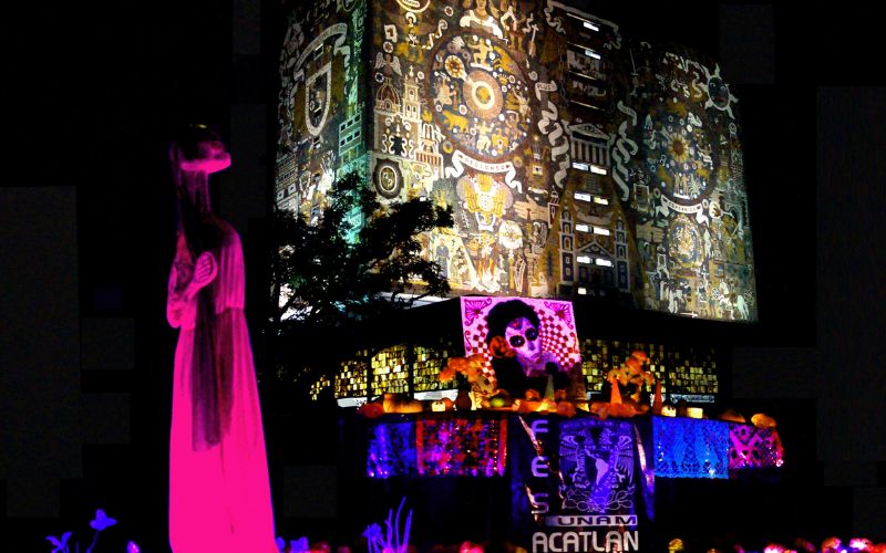 Ofrenda iluminada de la Megaofrenda UNAM frente a la Biblioteca Central en Ciudad Universitaria.