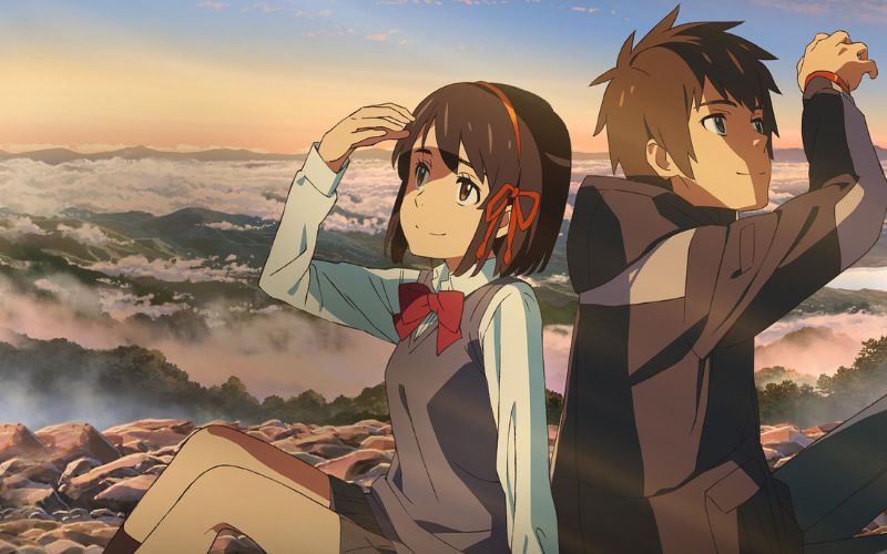 Mitsuha y Taki sentados sobre una montaña al amanecer en una escena de la película Your Name.