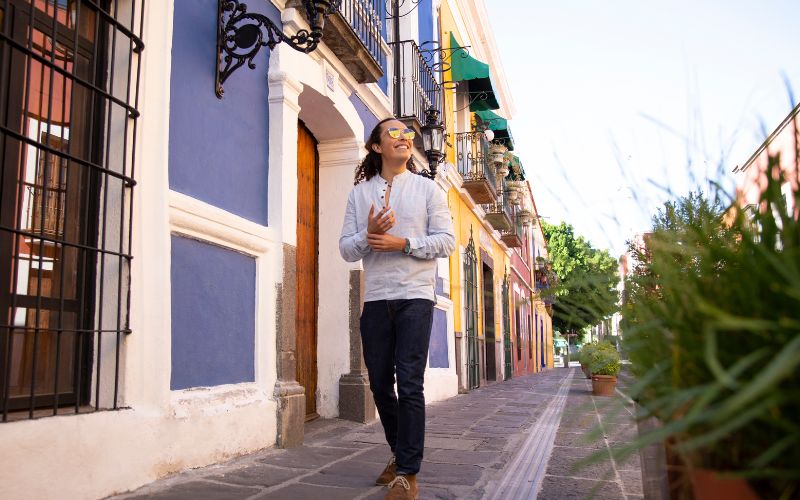 Persona caminando por calles coloniales de un Pueblo Mágico de Puebla, ideal para recorrer con calma, observar detalles y disfrutar el viaje sin prisas.